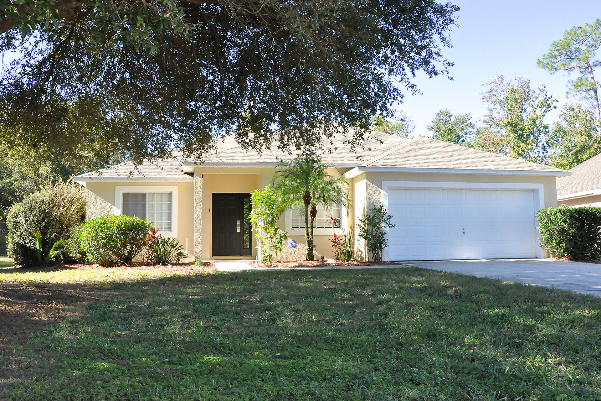Photo of Happy Oak Villa showing front of Villa on sunny day with large oak tree in foreground.